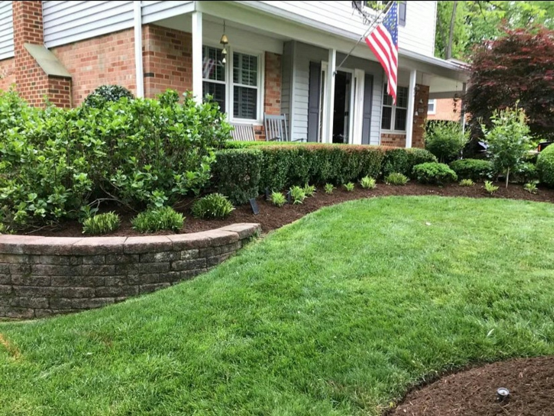 Landscape inspiration: established shrubs and planting beds bordered by a stone retaining wall